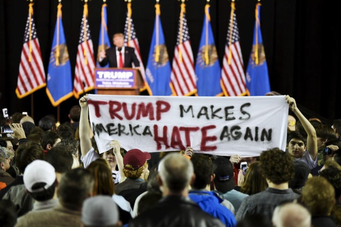 Protestors hold up a sign towards the crowd at a rally for U.S. Republican presidential candidate Donald Trump at Oral Roberts University in Tulsa, Oklahoma